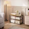 A shoe rack with various items placed on it, in a room with a lamp and a sofa. Produktbild-Vorschau
