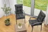 Two dark gray outdoor chairs with cushions are placed on a wooden floor next to a large window overlooking a garden. Produktbild-Vorschau
