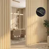 A room divider with vertical slats, showing a dining area in the background. Náhled obrázku produktu