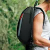 A person wearing a backpack outdoors. Produktbild-Vorschau