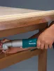 A person is using a cordless angle impact wrench to screw a screw into a wooden surface. Náhled obrázku produktu