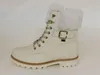 A white winter boot with a fur lining and gold accents is shown against a white background. Produktbild-Vorschau