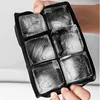 A hand holding a black silicone ice cube tray filled with ice cubes. Náhled obrázku produktu