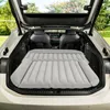 An inflatable mattress is laid out in the open trunk of a car, suggesting it's for camping or travel. Náhled obrázku produktu