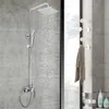 A modern shower system with a square showerhead and handheld showerhead mounted on a tiled wall. Náhled obrázku produktu