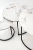 A set of three nesting tables with white marble-patterned tops and black metal frames, arranged on a white background. Produktbild-Vorschau