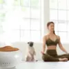 A woman is meditating with a pug dog next to her, with an aroma diffuser in the foreground. Podgląd zdjęcia produktu