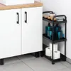A black 3-tier rolling cart filled with bathroom items, placed next to a white cabinet. Voir les images du produit