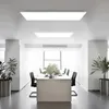 A modern office or meeting room with a long table and chairs, illuminated by ceiling panel lights. Anteprima dell’immagine prodotto