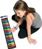 A young girl is playing a rainbow-colored roll-up piano keyboard. Produktbild-Vorschau