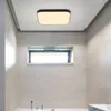 A modern bathroom with tiled walls and a ceiling light. Voir les images du produit