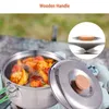 A camping cooking pot filled with food, placed outdoors on rocks. Produktbild-Vorschau