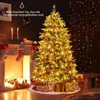 A decorated Christmas tree with lights and presents underneath, next to a fireplace with stockings. Náhled obrázku produktu