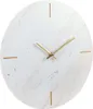 A close-up shot of a round wall clock with a marble-like pattern and gold hands. Voir les images du produit