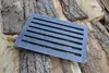 A cast iron grate rests on a pile of firewood. Náhled obrázku produktu