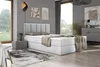 A bedroom scene featuring a bed, nightstand, rug, and artwork. Produktbild-Vorschau