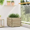 A wooden planter box filled with green plants sits on a patio next to a white railing. Náhľad obrázku produktu