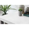 A close-up view of a textured white surface with a plant and decorative objects on it. Produktbild-Vorschau
