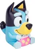 A toy dog figurine sitting down and holding a pink and yellow polka dot object. Produktbild-Vorschau