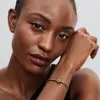 Close-up of a woman's face and arm, wearing a bracelet. Anteprima dell’immagine prodotto