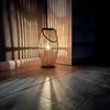 A wooden lantern casting striped shadows on a wall and floor. Anteprima dell’immagine prodotto