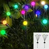 Solar-powered firefly lights illuminating a garden at night. Produktbild-Vorschau