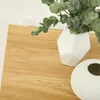 A close-up view of a wooden surface with two white vases and a plant. Produktbild-Vorschau