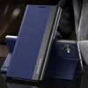 A navy blue flip case for a smartphone is shown in a studio setting, propped up to display its stand function. The phone itself is partially visible behind the case. Produktbild-Vorschau