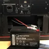 A close-up view of a battery being installed into a black electronic device. Produktbild-Vorschau