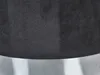 A close-up view of a black velvet pouf with a shiny metal base. Náhled obrázku produktu