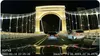 A night view from a car driving on a bridge, with other cars on the road and illuminated buildings in the background. Náhľad obrázku produktu