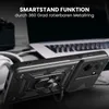 A black phone case with a ring stand is shown in a close-up shot, with a laptop and headphones blurred in the background. Produktbild-Vorschau