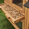 A close-up view of a wooden animal hutch with a pull-out tray filled with straw. Produktbild-Vorschau