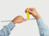 Hands using a yellow cable knife tool to cut a gray cable. Produktbild-Vorschau