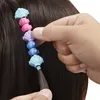 A hand is shown adding colorful beads to a strand of hair. Náhľad obrázku produktu