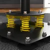 A close-up view of the base of a black freestanding punching bag, showing its shock-absorbing spring mechanism. Voir les images du produit
