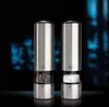 Two stainless steel electric salt and pepper grinders are displayed against a dark, blurred background with blue lights. Náhled obrázku produktu