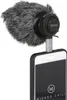 A microphone with a furry wind cover attached to a smartphone via a cable adapter. Produktbild-Vorschau