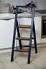 A step stool is placed in a kitchen setting, next to a sink and cabinets. Anteprima dell’immagine prodotto