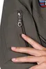 A close-up of a person's hand touching a zipper on a gray jacket. Produktbild-Vorschau
