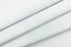 A close-up shot of white fabric, folded to show its texture and drape. Produktbild-Vorschau