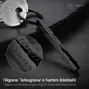 A close-up shot of a black metal keychain with engraved text, alongside a car key. The background is dark and textured. Voir les images du produit