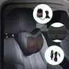 A black massage pillow is attached to the headrest of a car seat, with close-up insets showing the power adapter and the strap for attachment. Produktbild-Vorschau