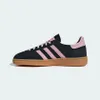 A side view of a black and pink Adidas sneaker with a brown sole. Produktbild-Vorschau