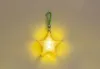 A yellow star-shaped LED light with a green carabiner attached. Produktbild-Vorschau