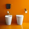 A modern bathroom with an orange wall and floor, featuring a bidet and a toilet. Anteprima dell’immagine prodotto