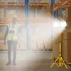 A worker in a warehouse is illuminated by a bright LED work light. Voir les images du produit