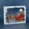 A Christmas advent calendar box with a depiction of Santa Claus and his reindeer flying through a snowy night sky. Produktbild-Vorschau