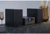 A stereo system with two speakers and a central unit is displayed on a dark wooden cabinet. Anteprima dell’immagine prodotto