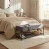 A bedroom scene with a bed, a bench, and a rug. Produktbild-Vorschau